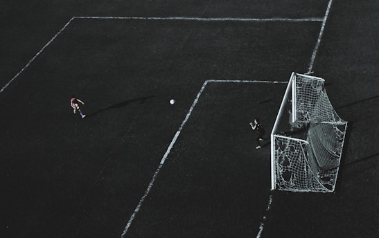 Close-up of a player aiming a powerful kick at the xutbol goal hoops.
