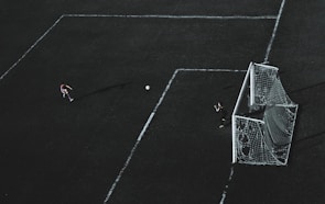 Action shot of a player making a powerful goal kick during a high-stakes game.
