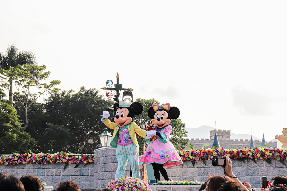 people in minnie mouse costume standing on the street during daytime