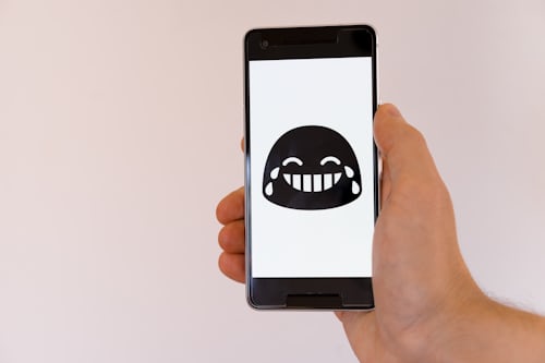 Telefonbildschirm mit lachendem und weinendem Emoji als Antwort auf lustige Fragen auf Instagram Stories. 