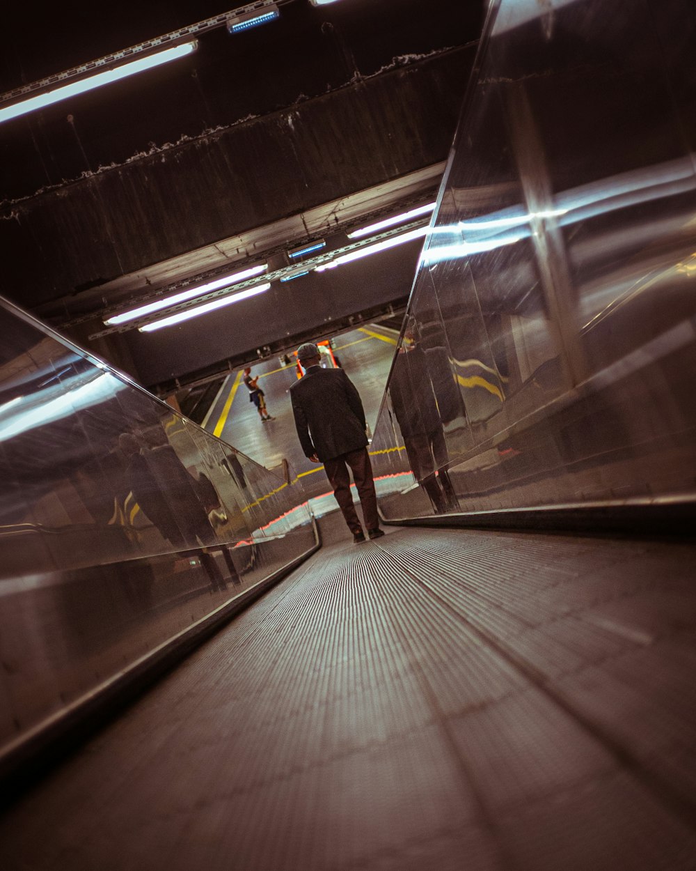 man in black jacket standing on train station