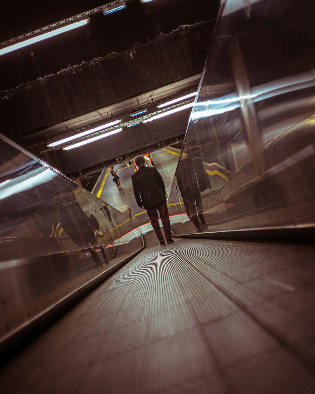 man in black jacket standing on train station