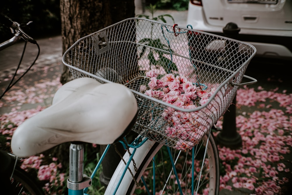 person holding white and pink flowers in basket