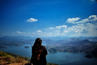 woman in black jacket standing on brown grass field near lake during daytime Wellness retreat mexico