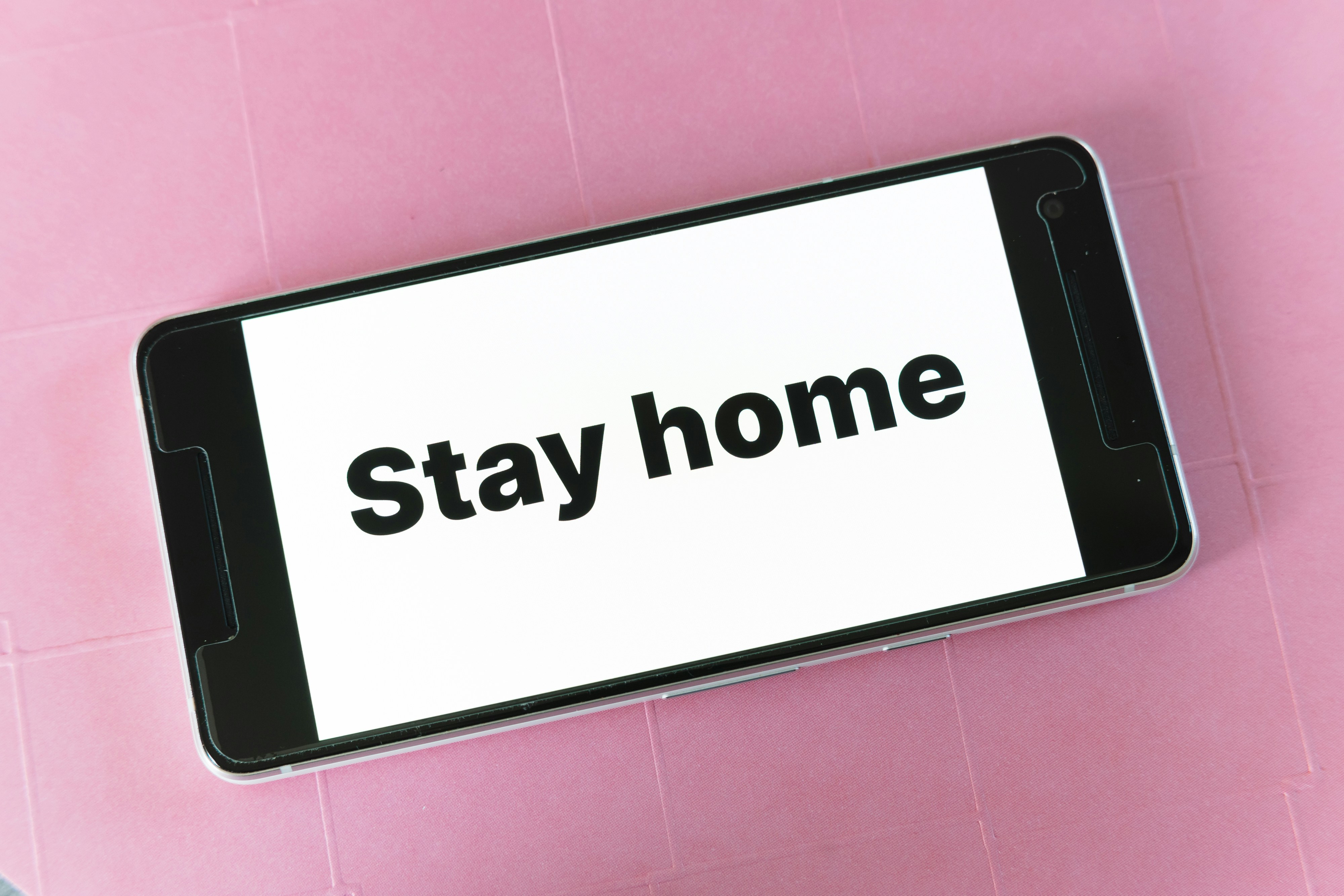 a cell phone with the words stay home on it