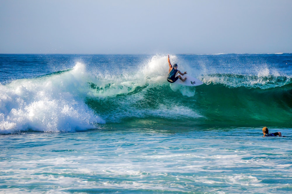 man surfing on sea waves during daytime