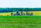 A group enjoying a countryside tour with green fields and historic buildings in the background.