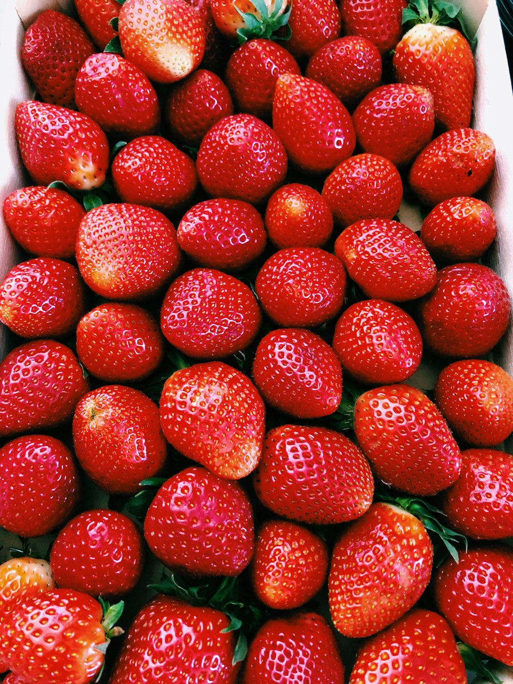 rote Erdbeeren auf weißer Keramikplatte