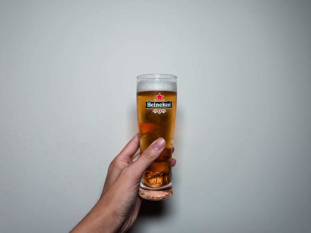 person holding clear drinking glass with beer