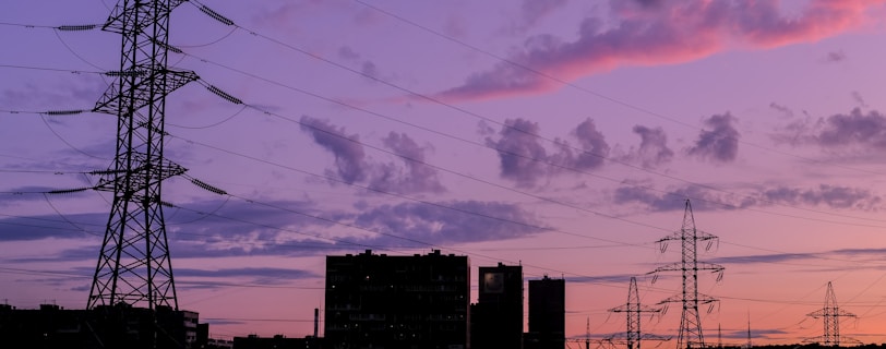 silhouette of buildings under cloudy sky during sunset powered by solar