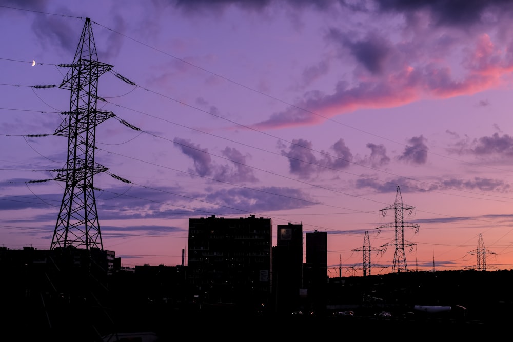 silueta de edificios bajo un cielo nublado durante la puesta de sol