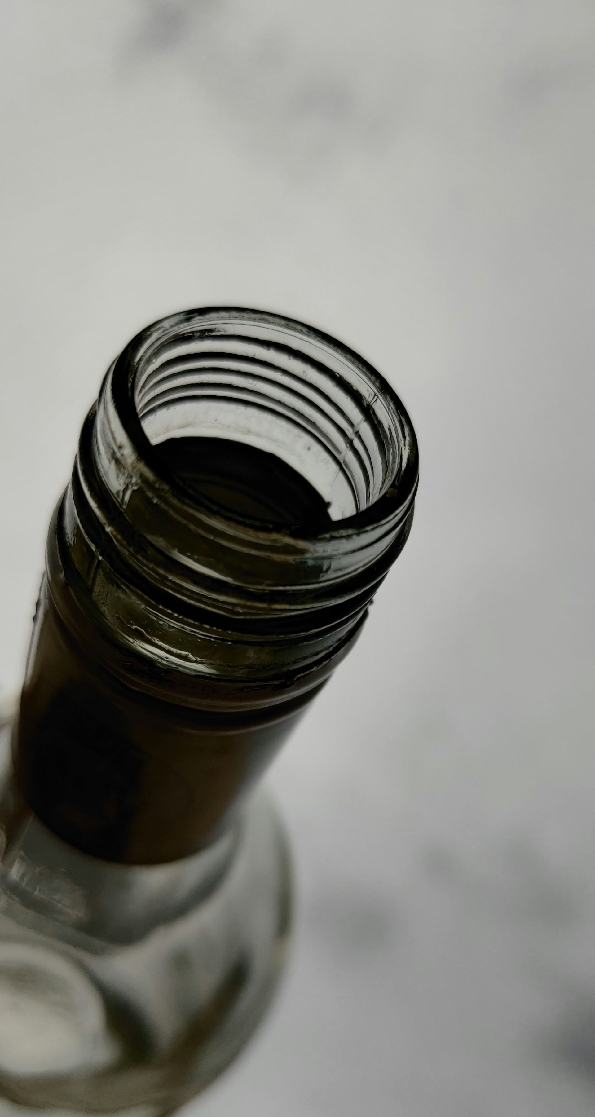 A bottle brush reaching deep inside a narrow glass bottle, demonstrating its flexible neck and thorough cleaning power.