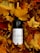 A bottle of Ridge White wine lies partially covered by a dense layer of vibrant autumn leaves. The rich colors of the leaves, ranging from deep red to bright yellow, create a warm and cozy background for the dark glass bottle.