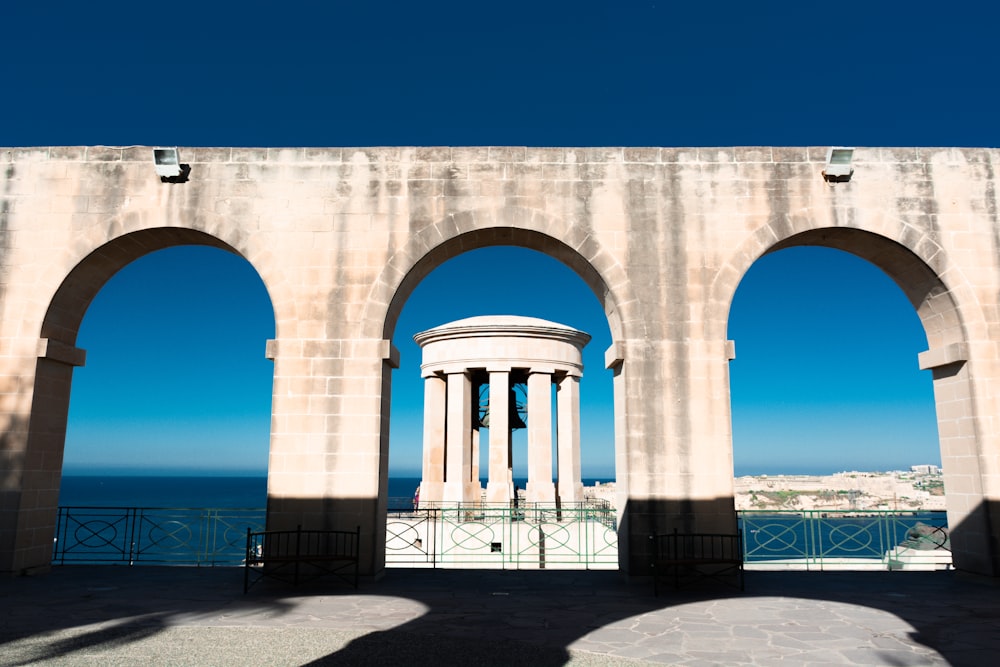 white concrete arch near body of water during daytime