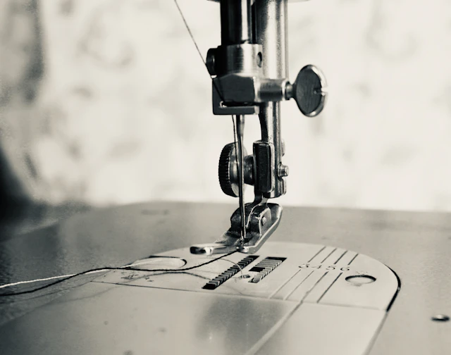 Detalle del prensatelas de una máquina de coser sobre la tela