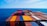 High-resolution photo of a cargo ship loaded with colorful containers under a bright sky.