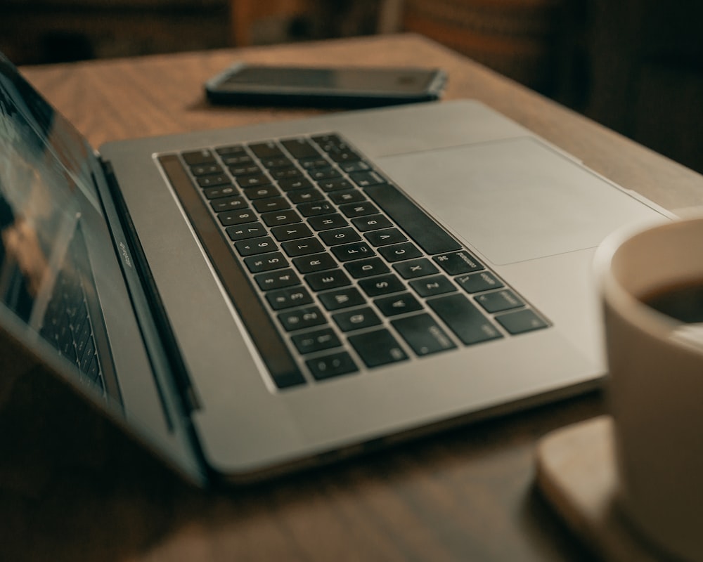 茶色の木製テーブルの上のMacBook Pro