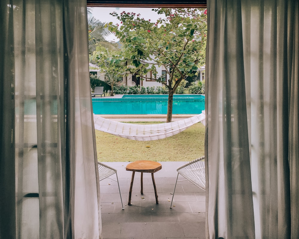 brown wooden table near swimming pool