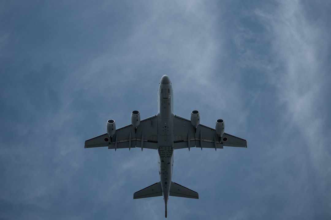 gray airplane under white clouds during daytime,