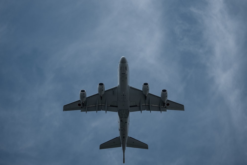 gray airplane under white clouds during daytime