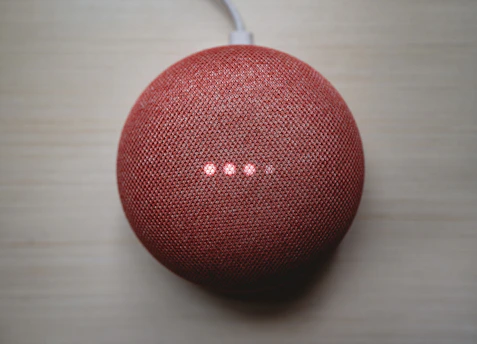 A compact TV box device with glowing LED lights on a wooden table