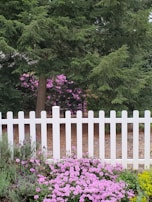White picket fence barrier framing a colorful flower garden