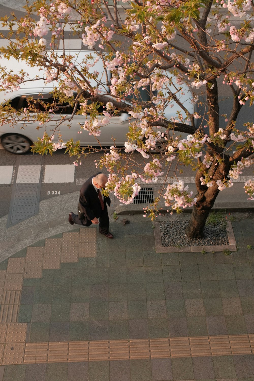 man in black suit standing near white car during daytime