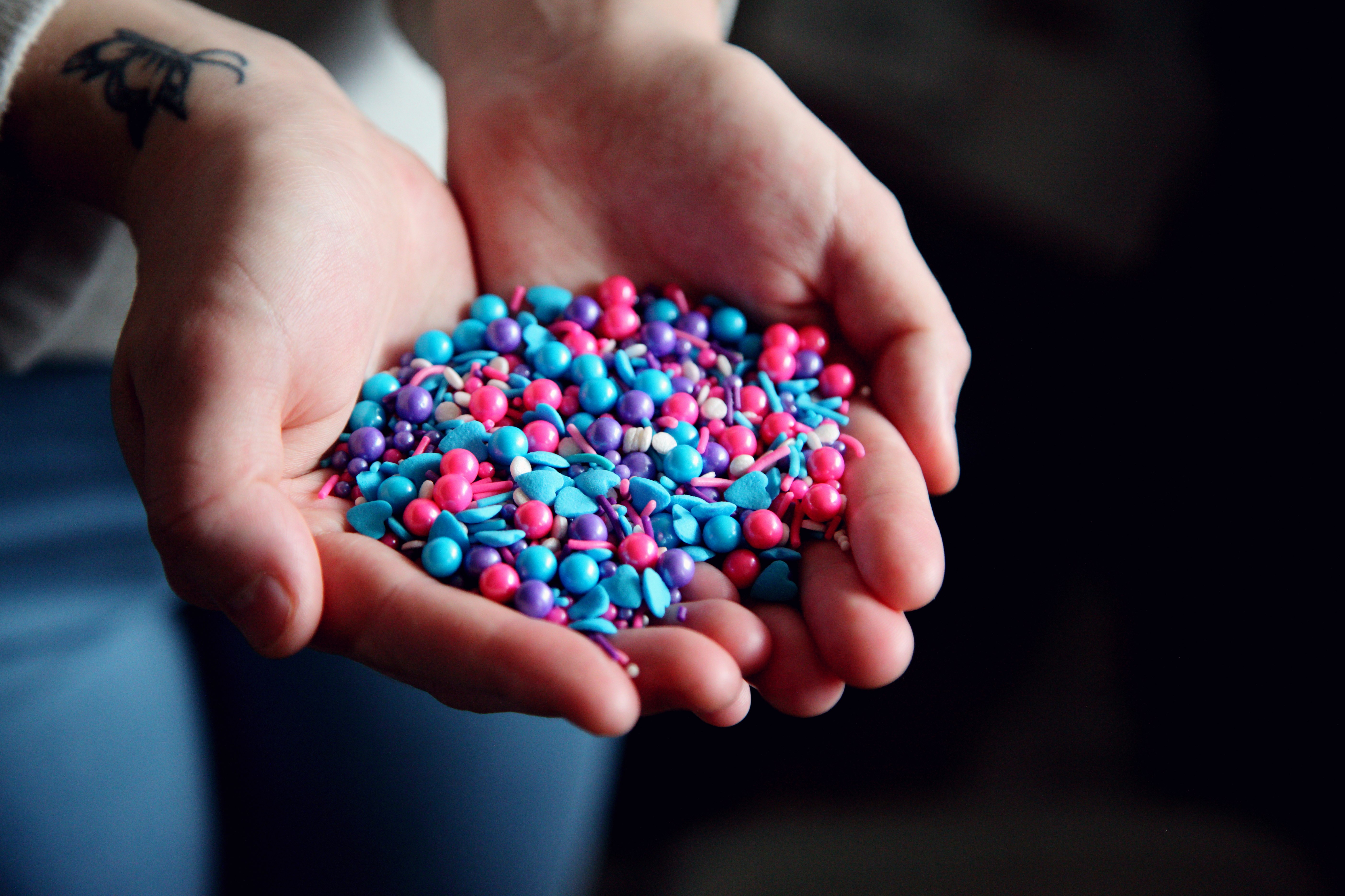person holding pink blue and white beads