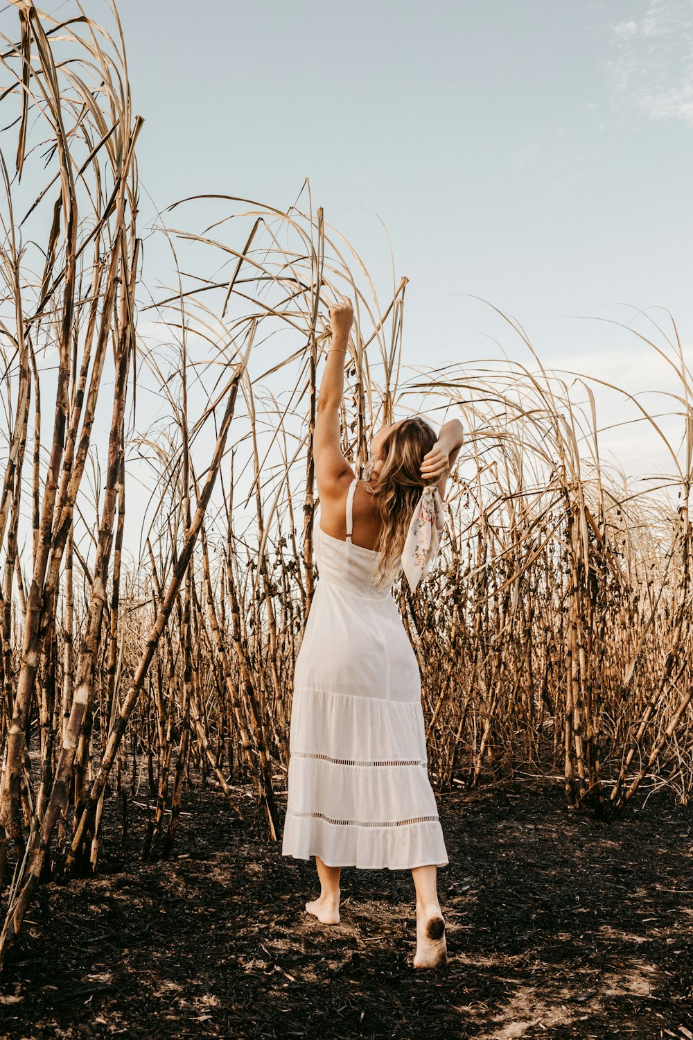 woman in white dress standing on brown grass field during daytime