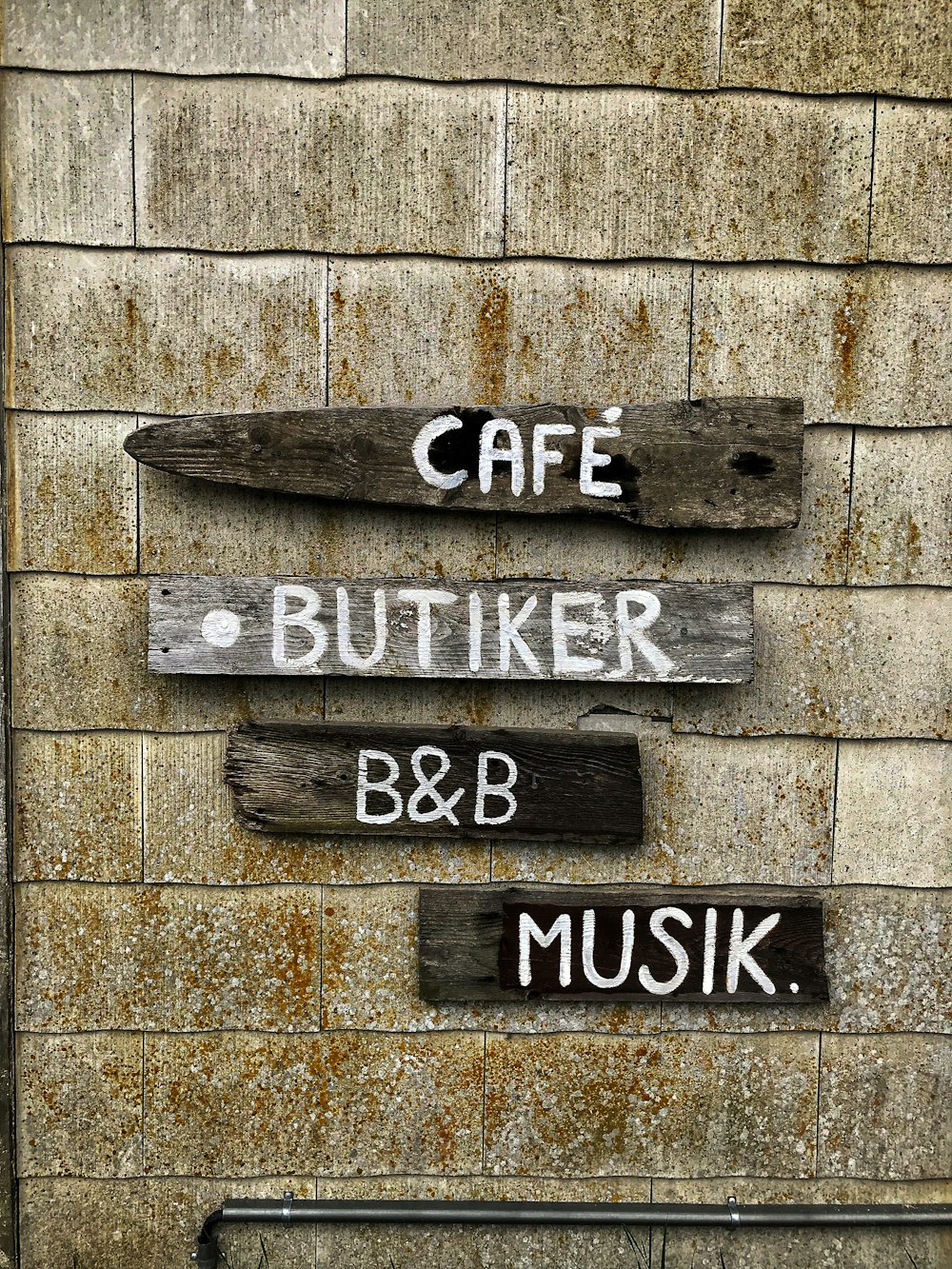 a sign on a brick wall that says cafe, butter, b & b,