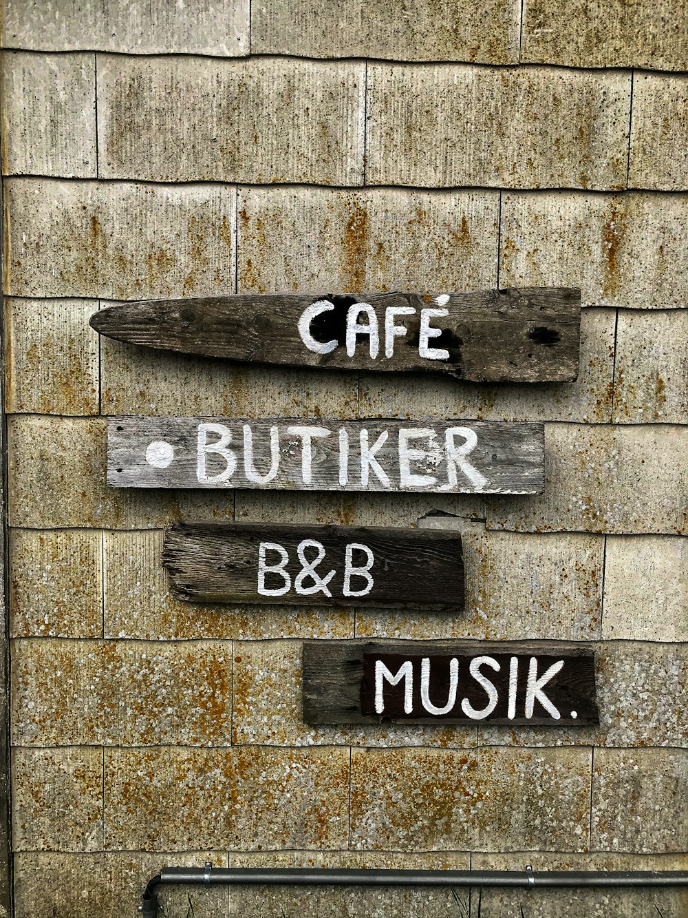 ein Schild an einer Ziegelmauer, auf dem Café, Butter, B & B steht,