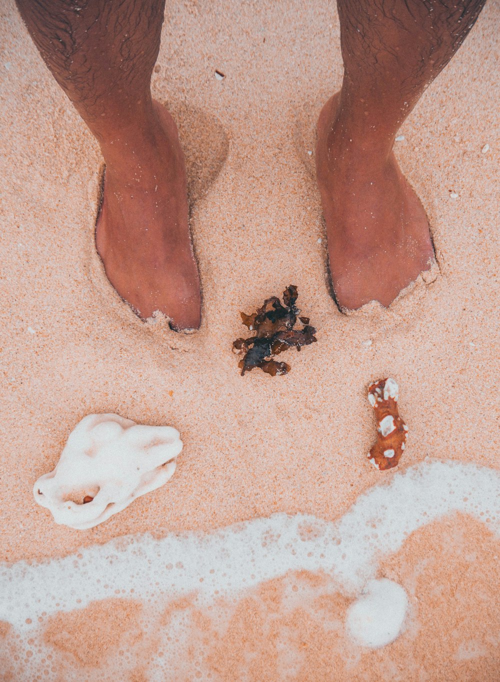 persons foot on white sand