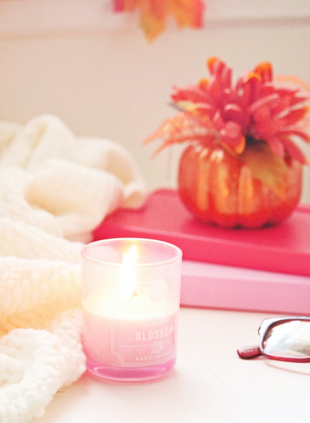 a candle sitting on top of a table next to a pair of glasses