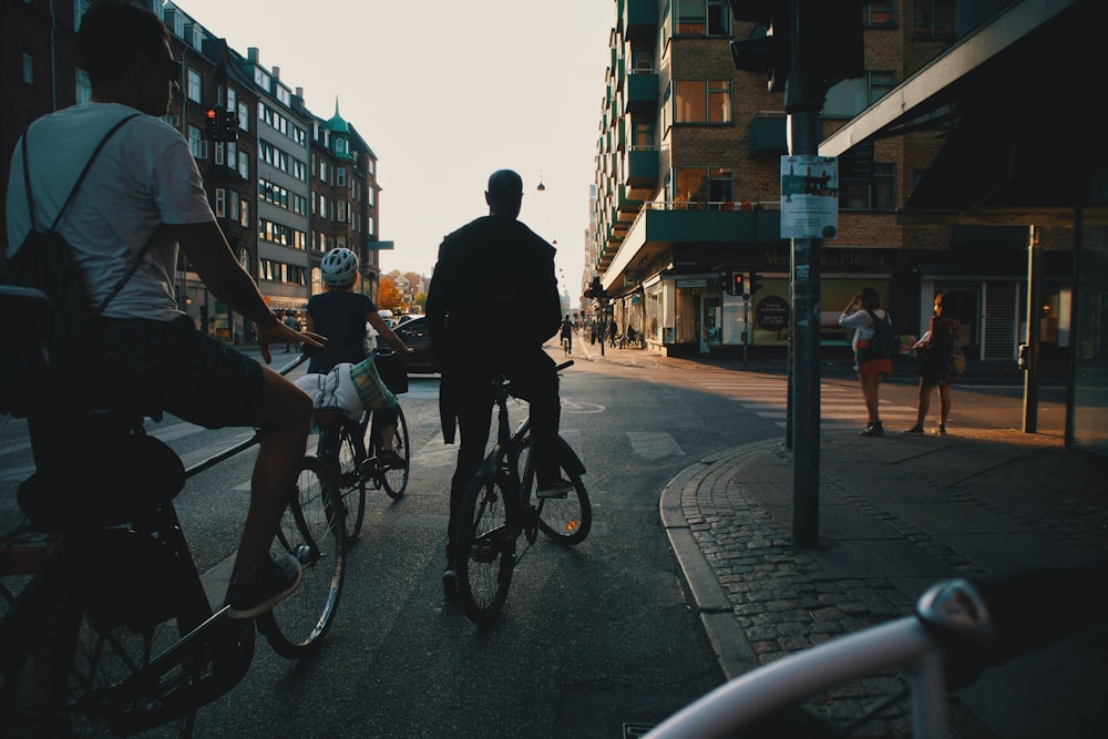 Mann in schwarzer Jacke fährt tagsüber Fahrrad auf der Straße