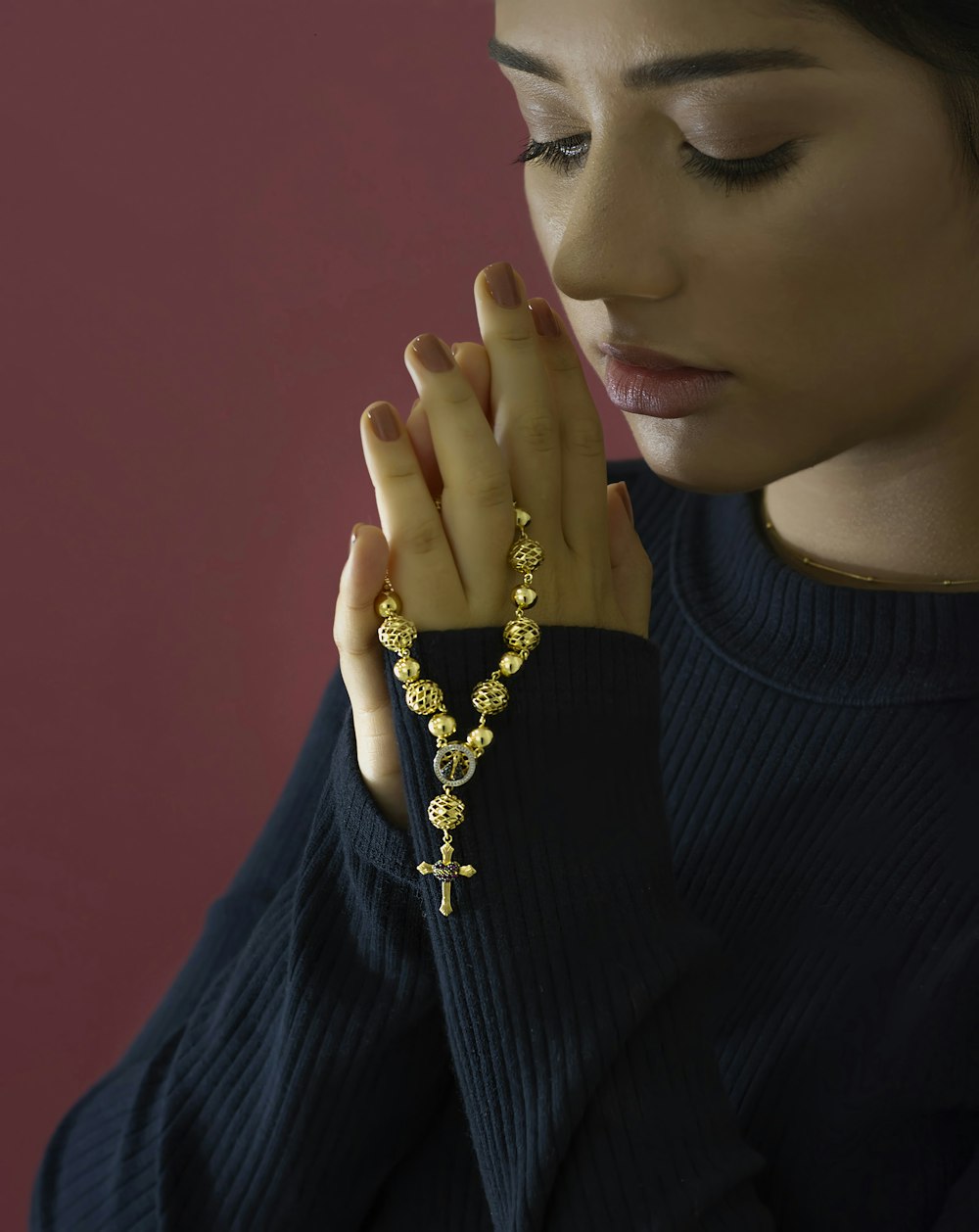 Frau im schwarzen Rollkragenpullover mit goldener Halskette