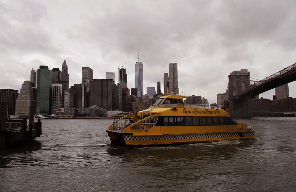 yellow and black boat on water near city buildings during daytime