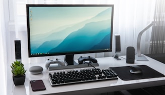 black computer keyboard beside silver imac