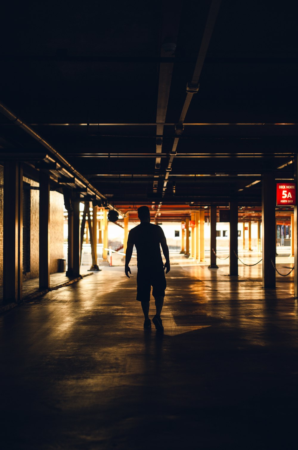 man in black jacket walking on hallway