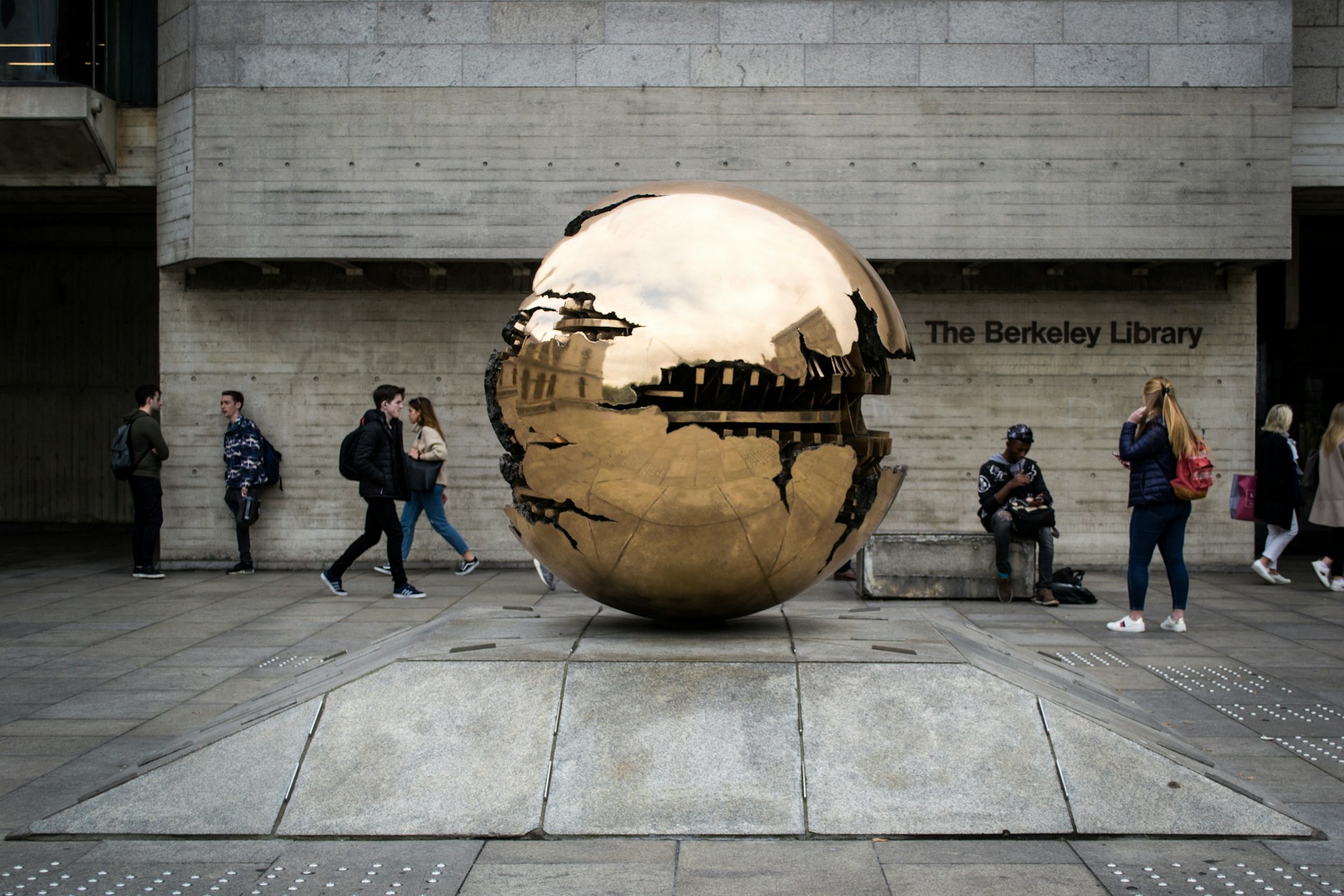 people walking on sidewalk near white and brown round ball