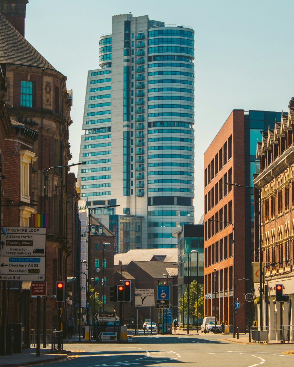 cars parked on side of the road near high rise buildings during daytime