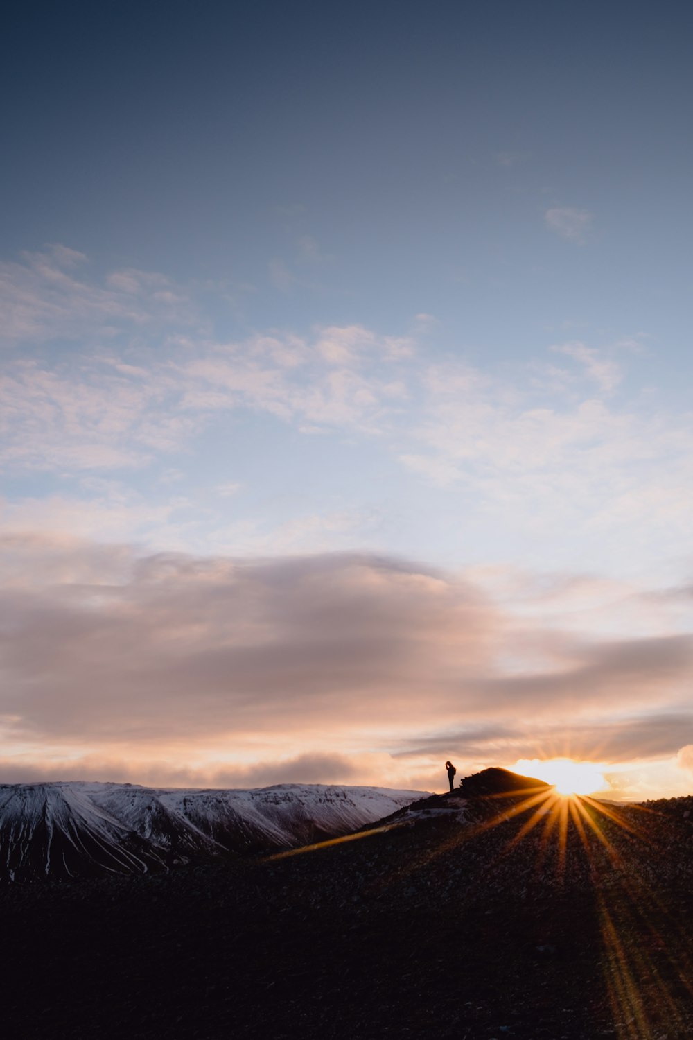 silhouette of mountain under cloudy sky during sunset