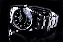silver and black round analog rolex