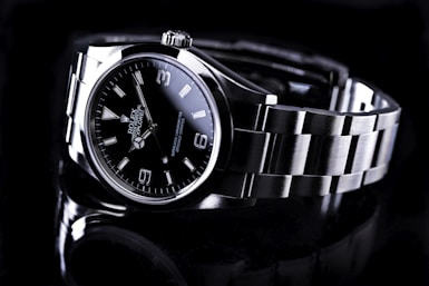 silver and black round Rolex