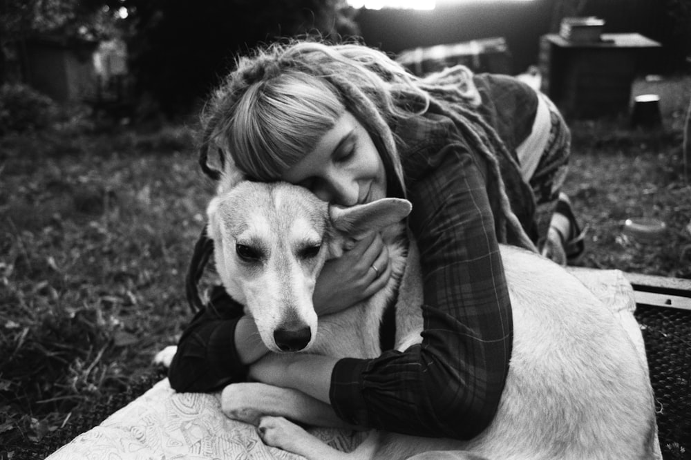 grayscale photo of woman hugging dog