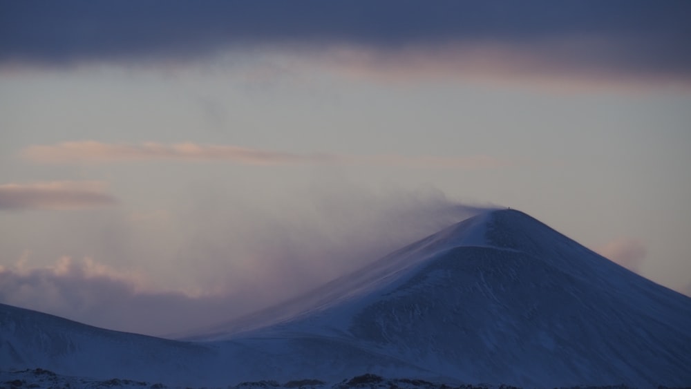 white clouds over snow covered mountain