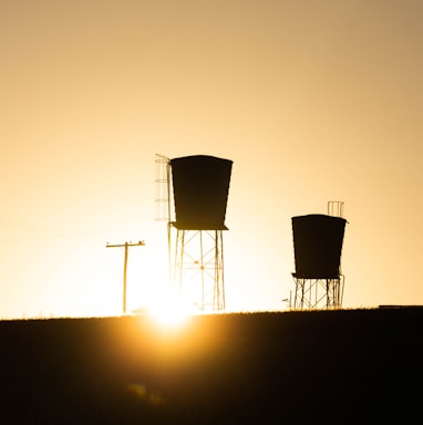 silhouette of wind turbines during sunset