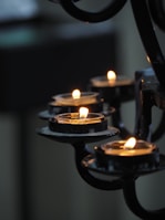 lighted candles on black metal candle holder