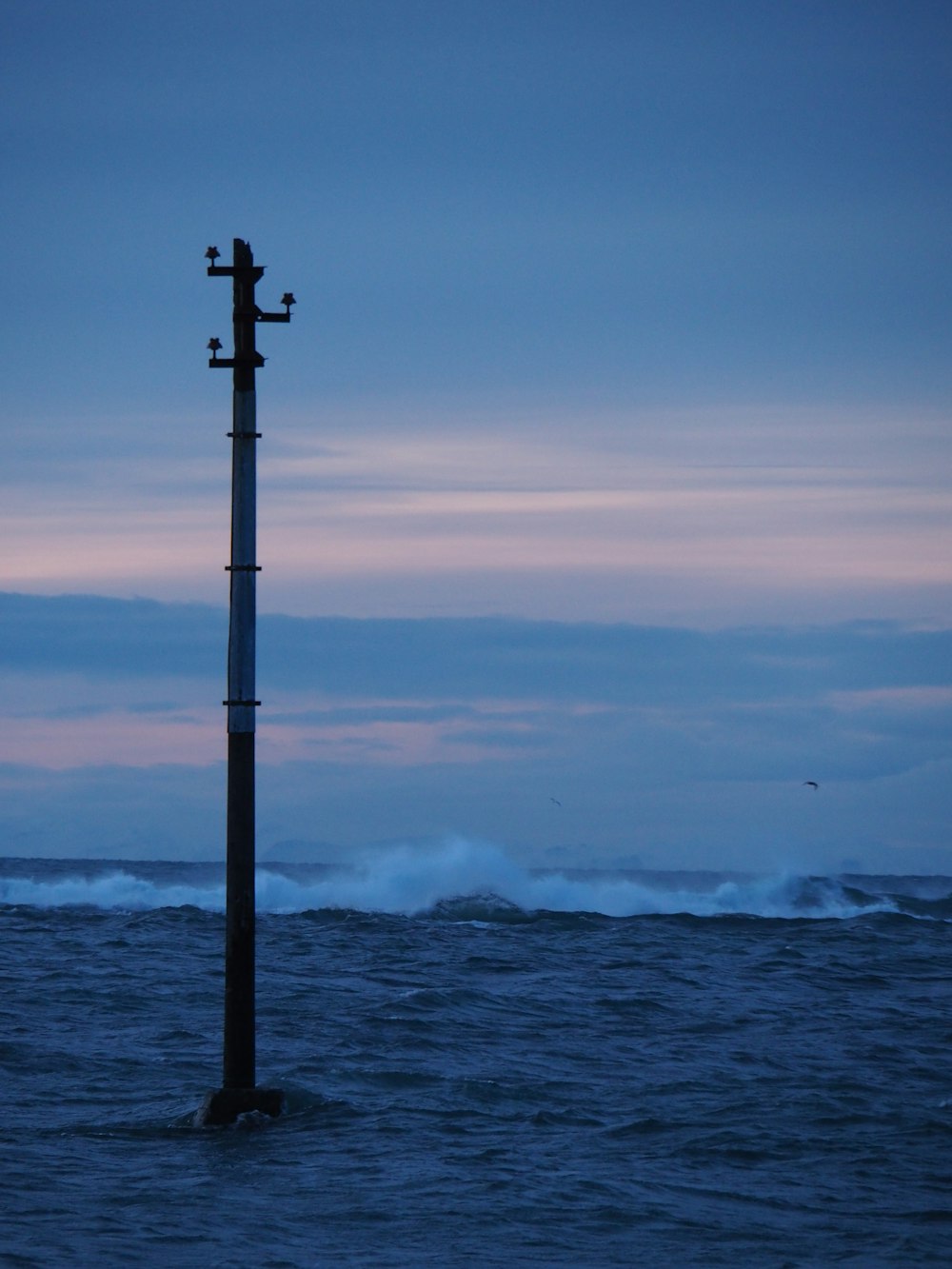 black metal post near sea during daytime