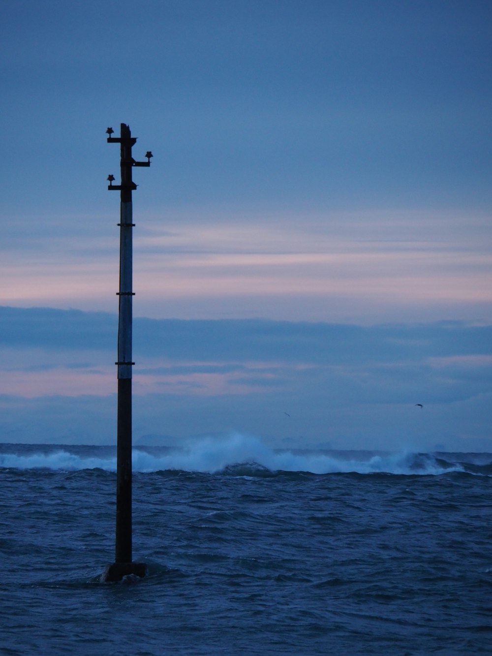 palo di metallo nero vicino al mare durante il giorno