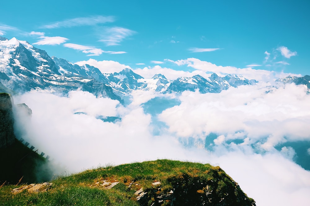 green grass covered mountain under white clouds and blue sky during daytime